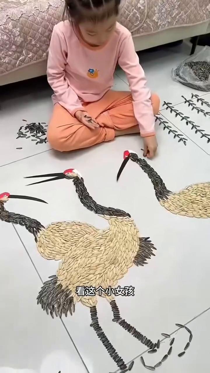 看这个小女孩，不仅用瓜子拼出了公鸡的模样，还拼出了牛拉车的场景，甚至还拼出了百鸟