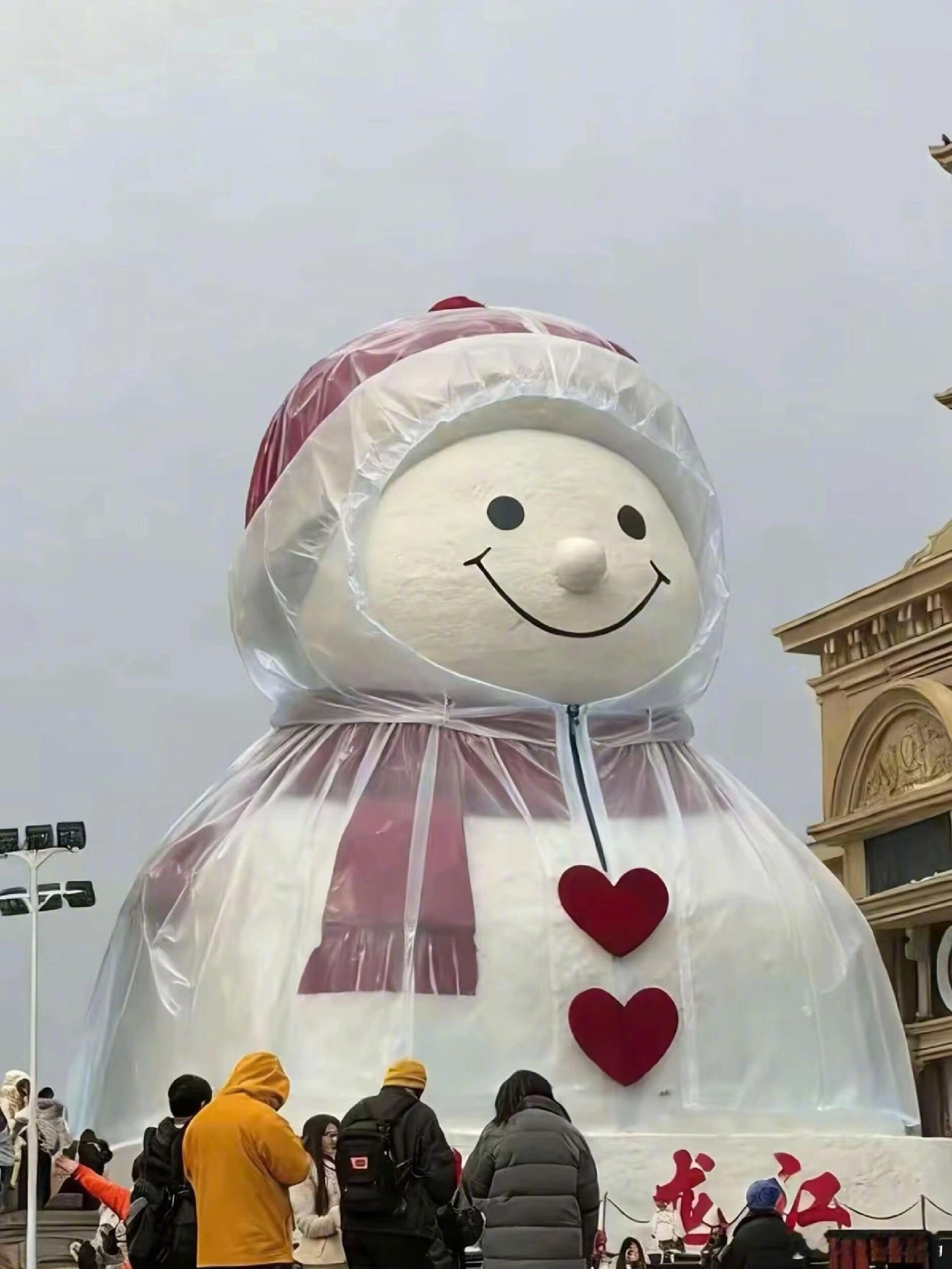 哈尔滨大雪人穿雨衣也要上班