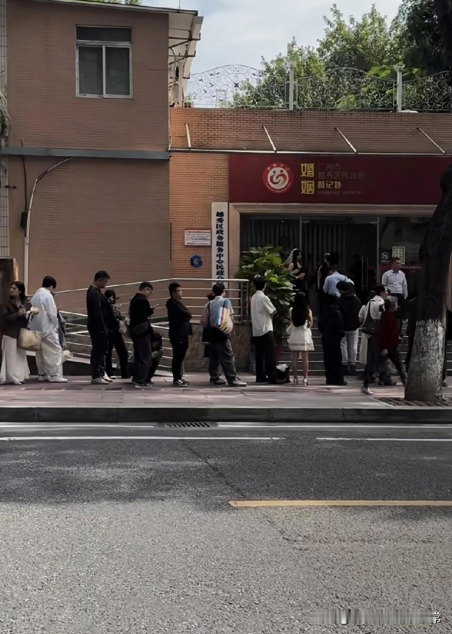 广州民政局结婚登记处挤爆了!瞧瞧这结婚的阵仗,新人扎堆领证,连户外花墙都挤