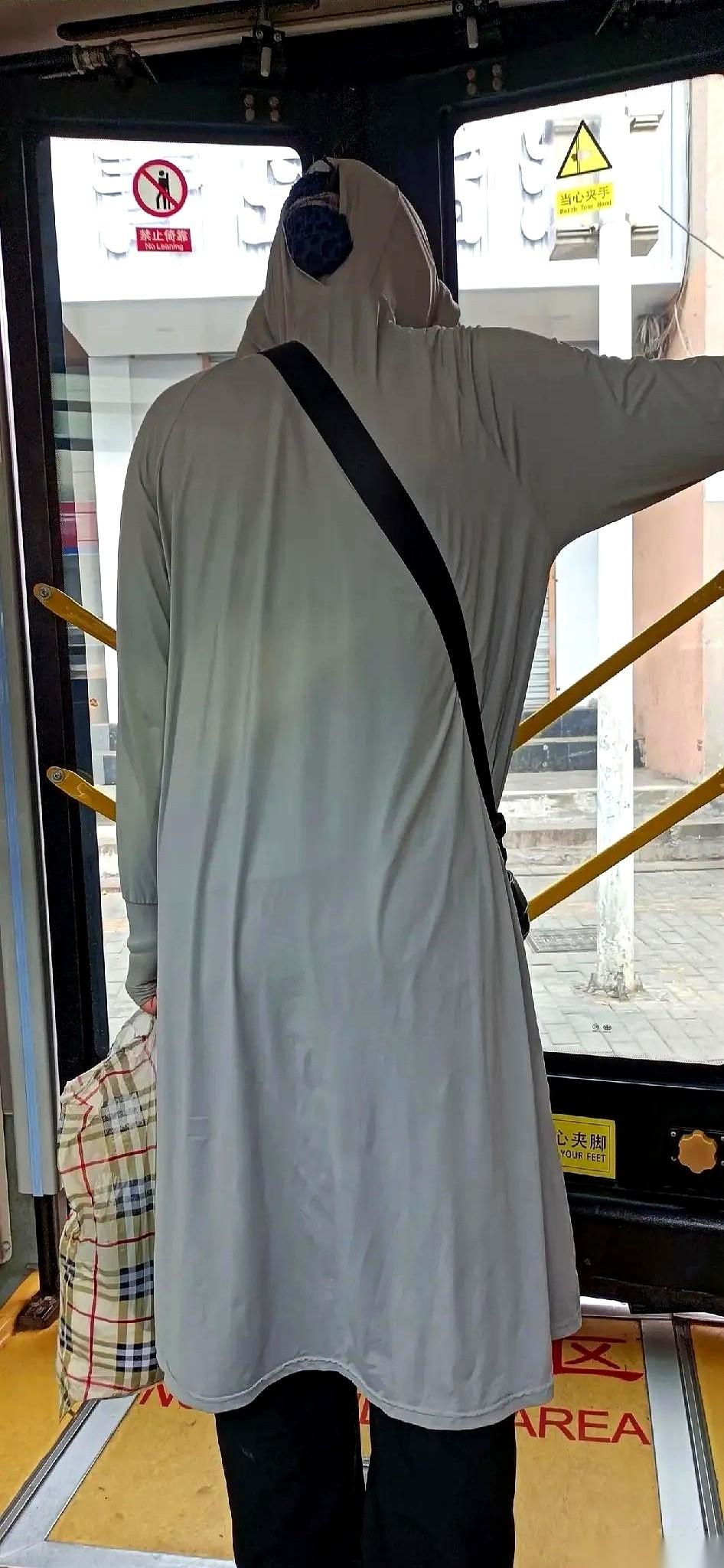 今年夏天，街上冒出一种“新物种”。一件长到脚脖子的防晒服，把人从头到脚裹得密不