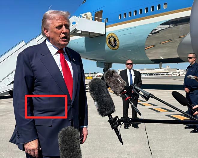 特朗普刚下飞机，腰间藏的盒子就被盯上了。特朗普腰上这个方方的盒子在西服上的轮廓