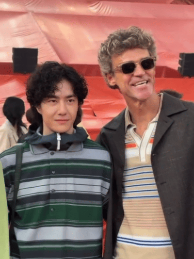 王一博如此乖萌卷发造型的反差感真的绝了！合照时安安静静站在一旁，身姿挺拔又软萌乖