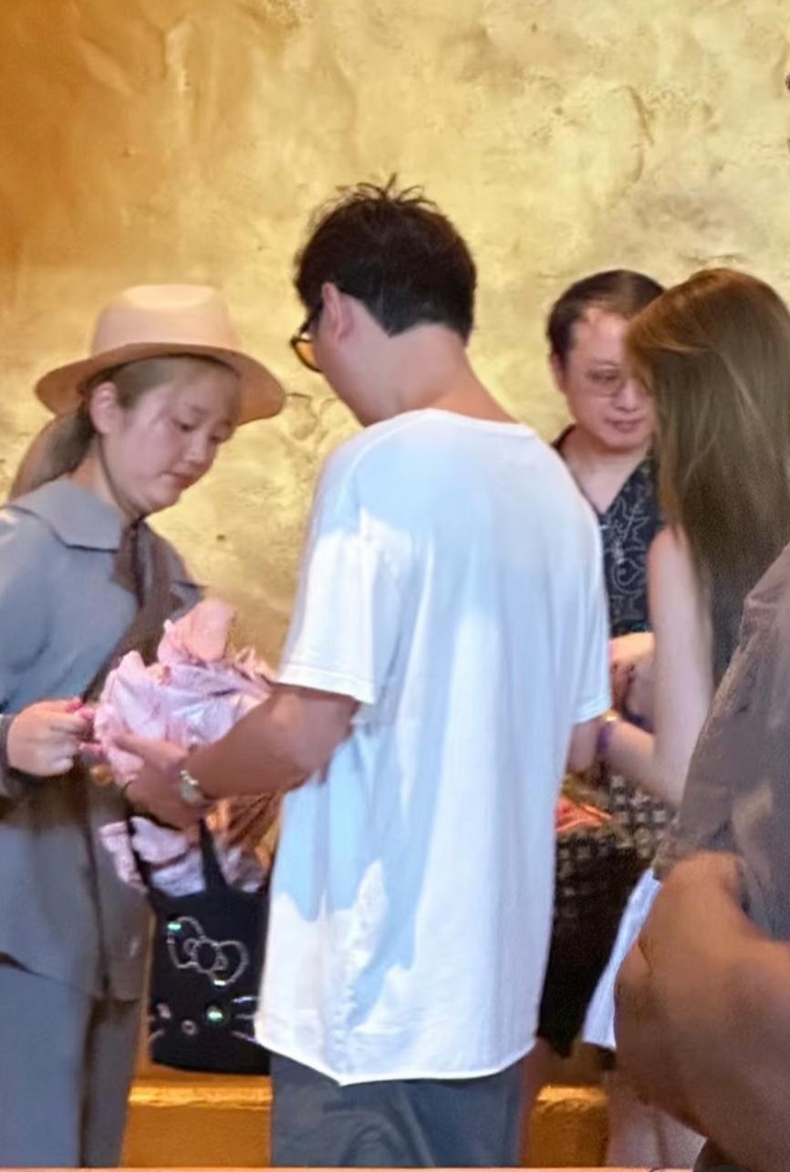 王思聪大阪环球携“正牌女友”懒懒同游，二人用着同款手机链，王思聪亲自撑伞遮阳，懒