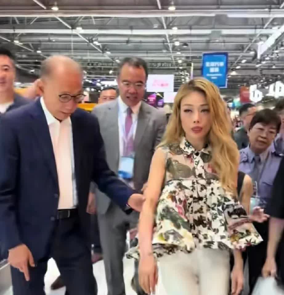 容祖儿和她的老板一起去参观车展。当下台阶的时候，她的老板小心翼翼的挽起她