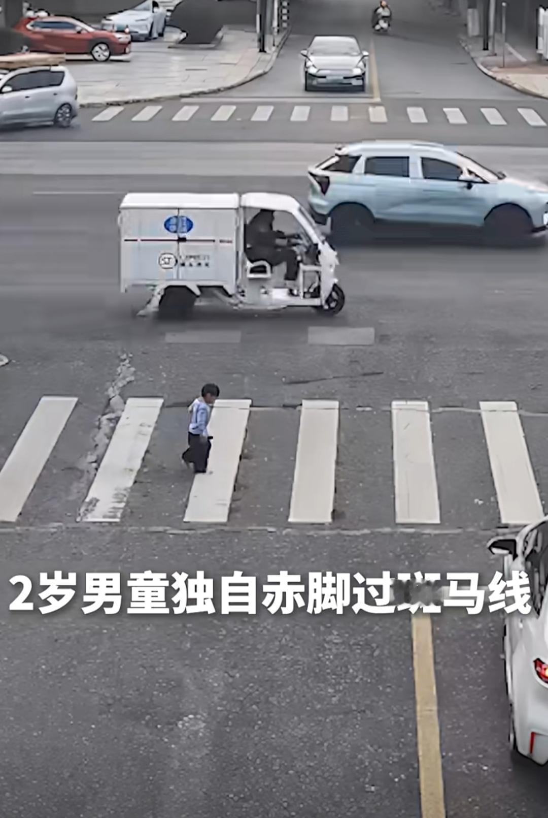 监控画面里，浙江嘉兴的晚高峰车流中，一个2岁男童光着脚丫，摇摇晃晃地走在斑马线上