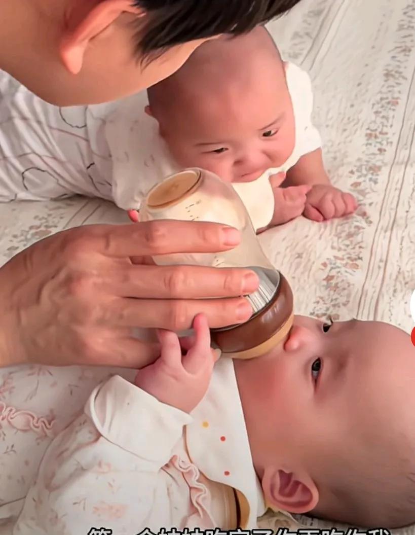 爸爸带龙凤胎好会协调，喂妹妹吃奶时，让哥哥先玩会柚子等一等，边喂妹妹，边对哥