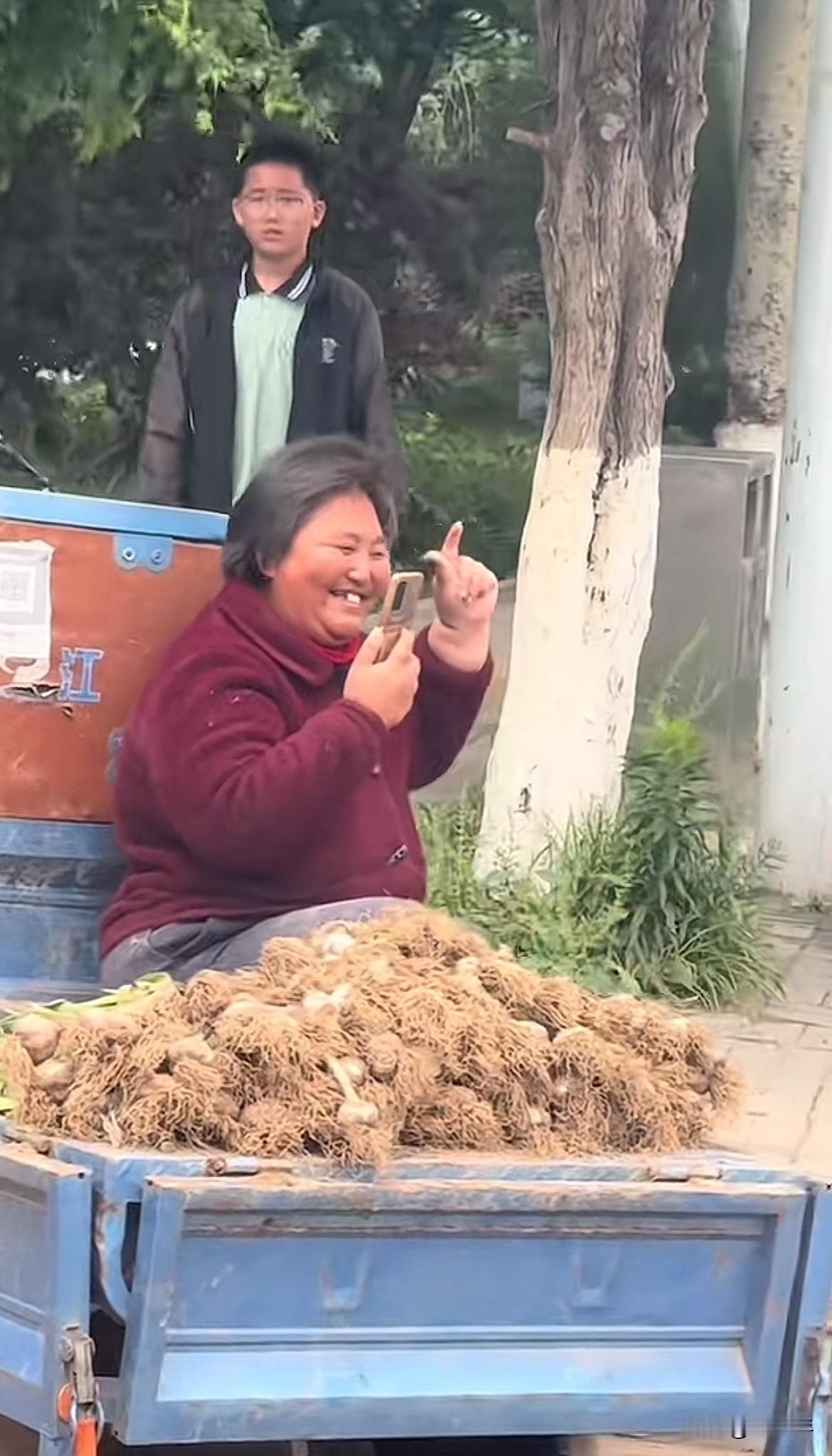 网友拍下的这位卖蒜大姐的笑容太让人羡慕了！说话间眉眼皆是自在，活的通透又洒脱！跟