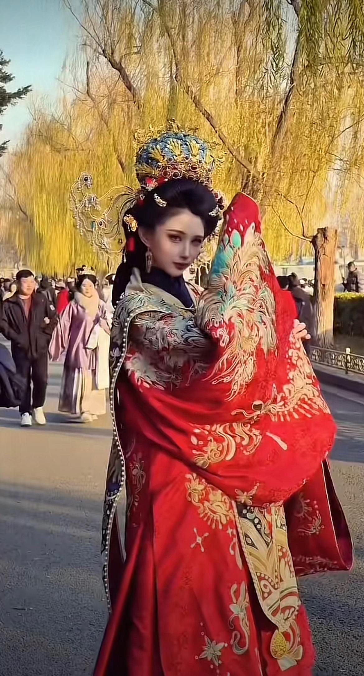 美女穿着凤冠霞帔，给人一种特别惊艳之感，正巧另一位美女穿着格格服饰，骑着共享单车