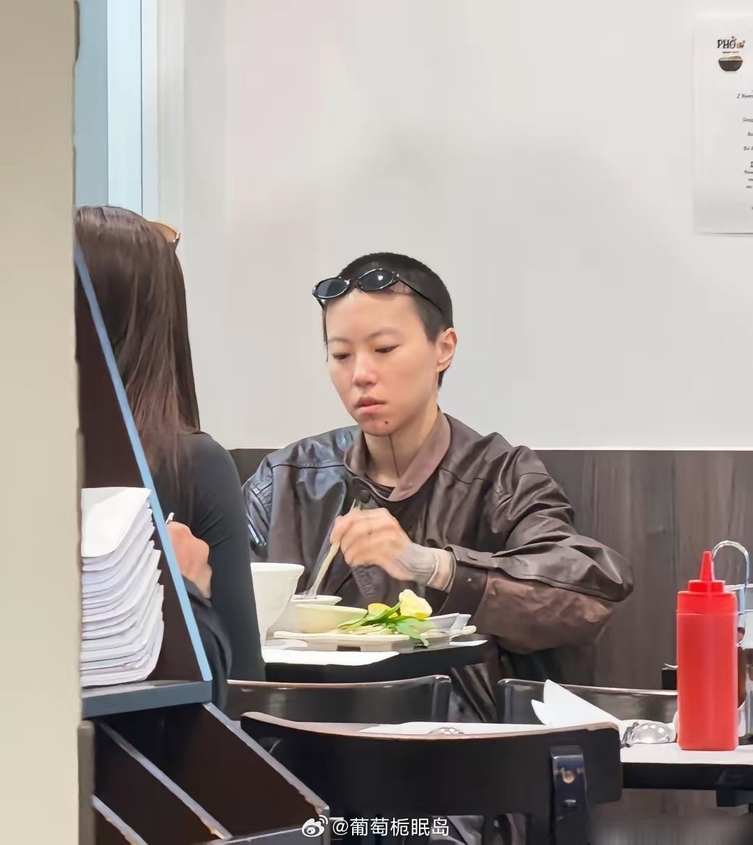 29岁窦靖童在法国巴黎一家餐馆吃汤面被偶遇，她留着寸头短发，下巴刺了纹身，中性打