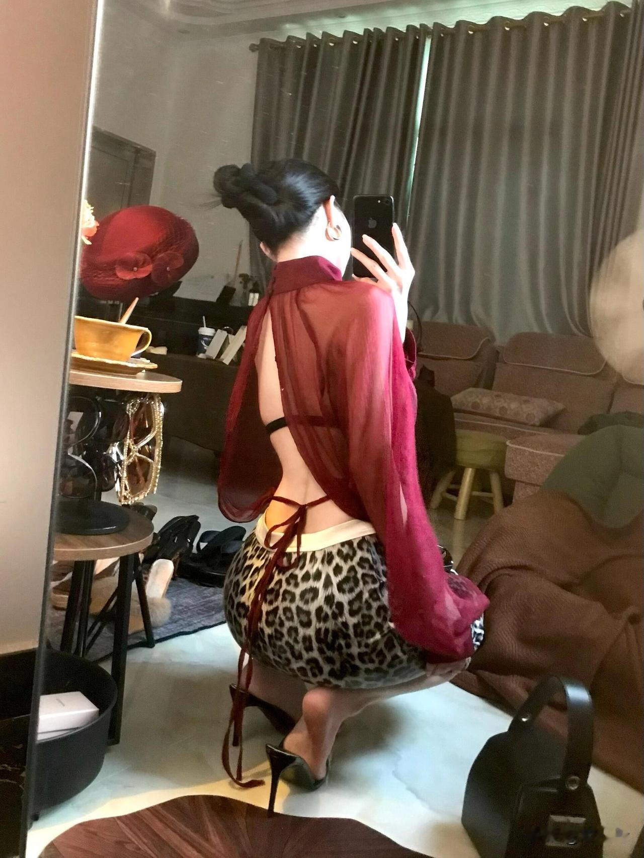 在镜子里自拍，穿着红色衬衫。