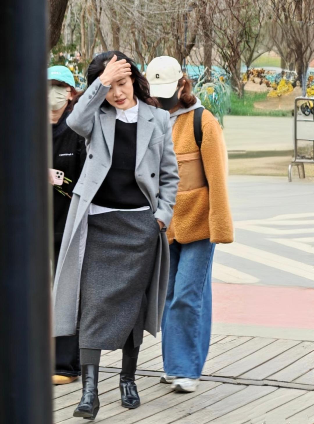 58岁的周涛现身北京朗园，一件浅灰色的挺括大衣，内搭白衫灰裙，秀发丝滑如缎，气质