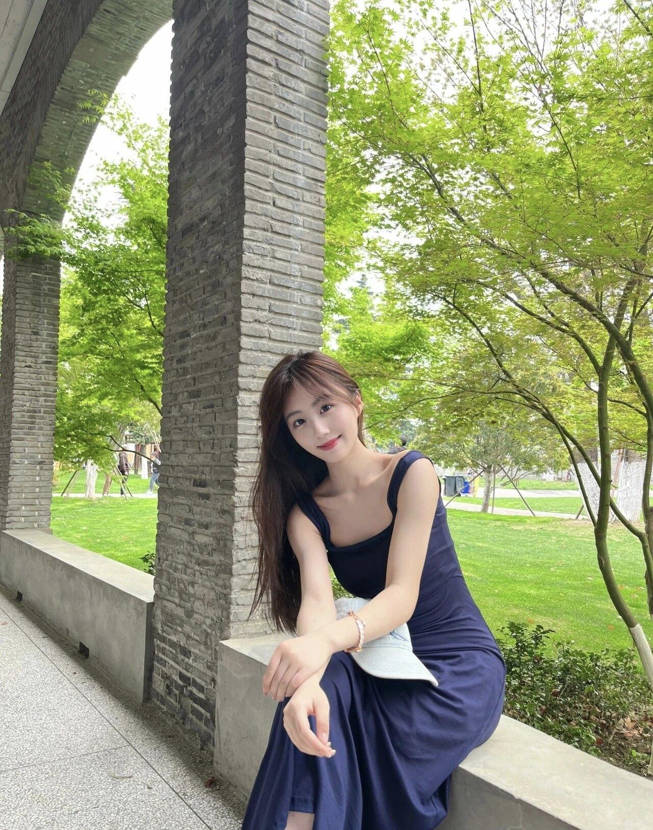 优雅蓝裙少女，静坐绿荫长廊，享受宁静时光。