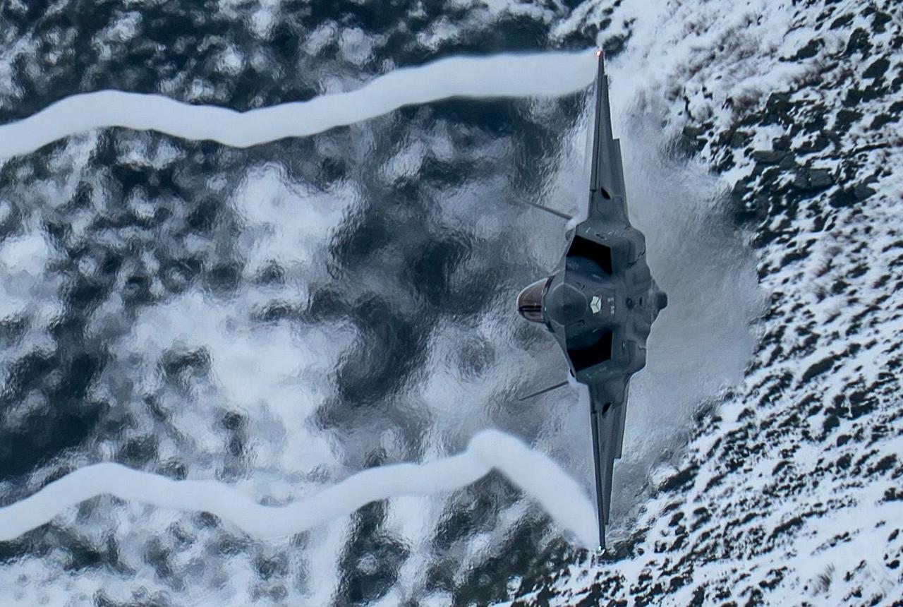 战机欣赏：在白雪覆盖的马赫谷，低空通场的F-35战斗机。翼尖拉出了白色的气流，突