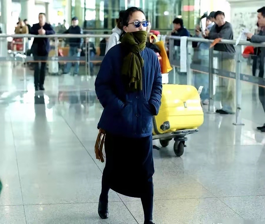 周迅这身打扮，简直是在打脸半个时尚圈。深蓝色长款羽绒服，底下拖着个深色长裙，脖子