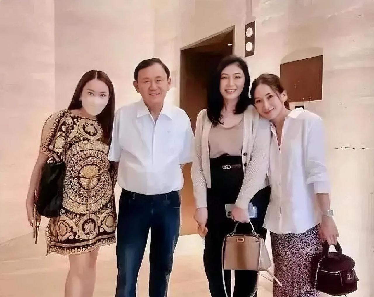 泰国人他信与妹妹英拉及两个女儿的亲情合影。从照片中可以看到，他信家族生活优渥不