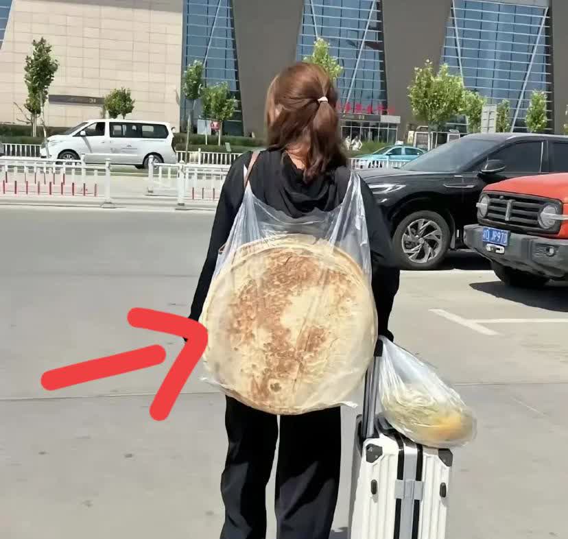 广东深圳，一名男子到深圳找工作，在火车站看到一名女子推着行李箱，背上背着两个很大