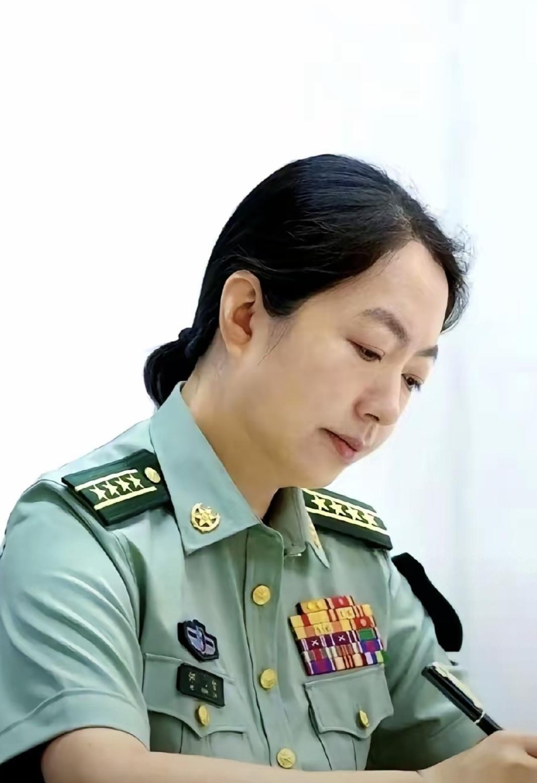 照片里那个女大校，肩章是两杠四星，胸前勋表密密麻麻六排，第一眼真没注意脸，光盯那