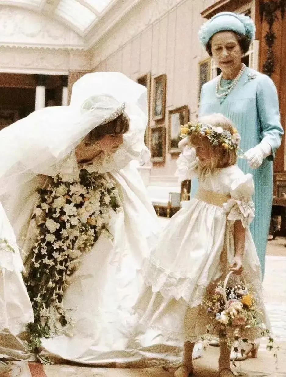 1981年，戴安娜与查尔斯大婚当天，戴安娜与女王和小花童的一张留影，照片中可爱的