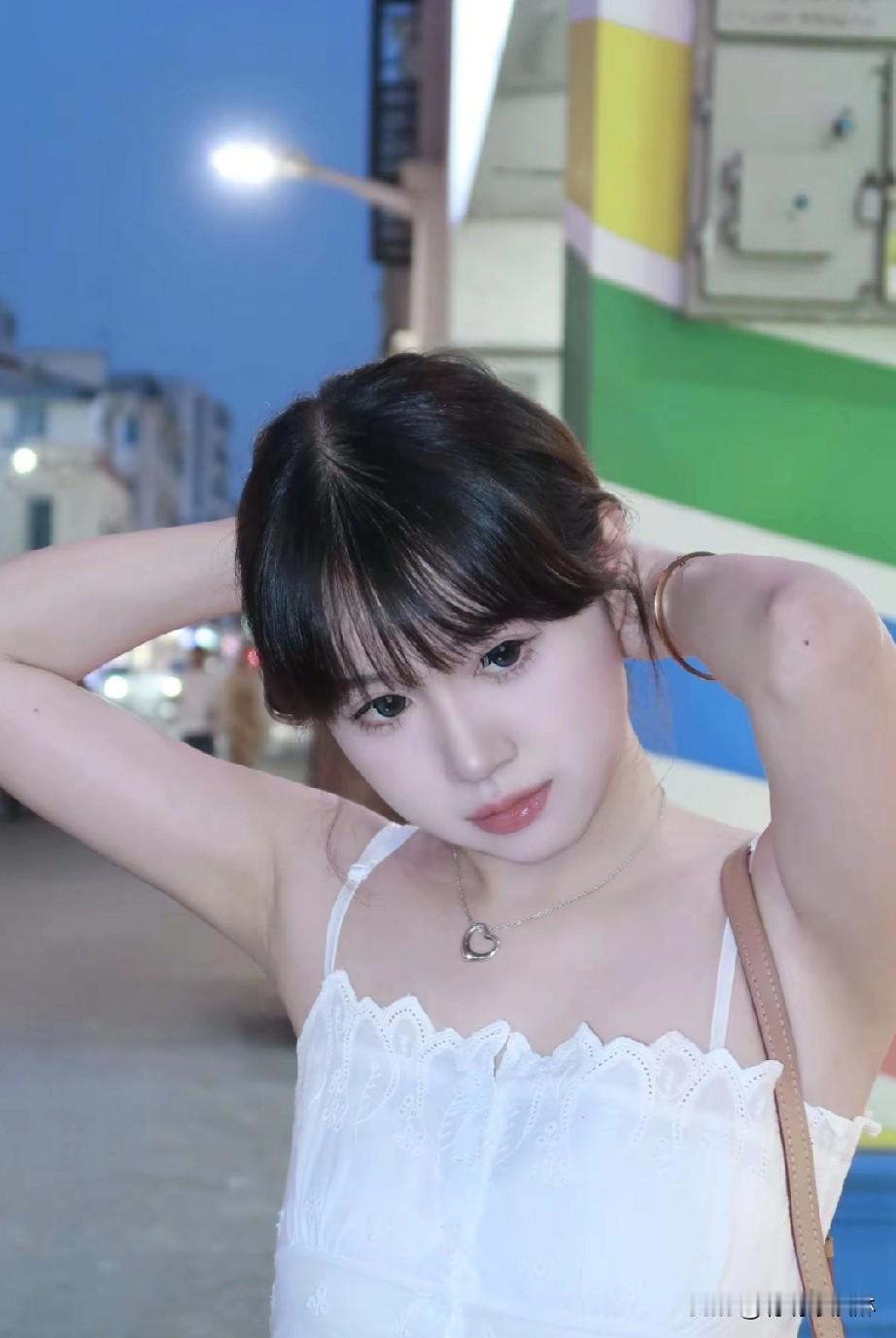 夜晚街头的甜美少女，白色蕾丝裙搭配精致项链，散发着温柔与优雅。