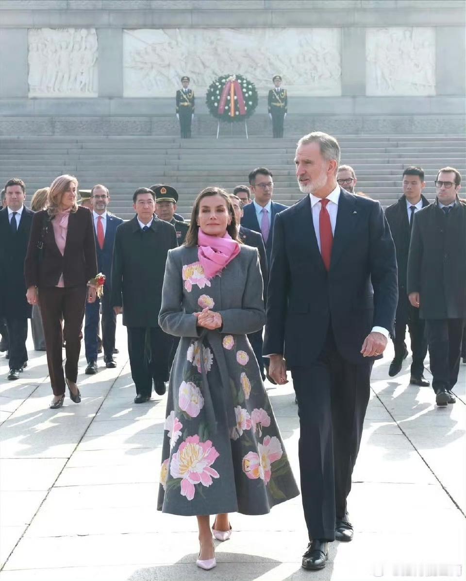 来自西班牙的客人，王妃造型很惊艳，粉色围巾，灰色长大衣，点缀图案颇具中国元素，下