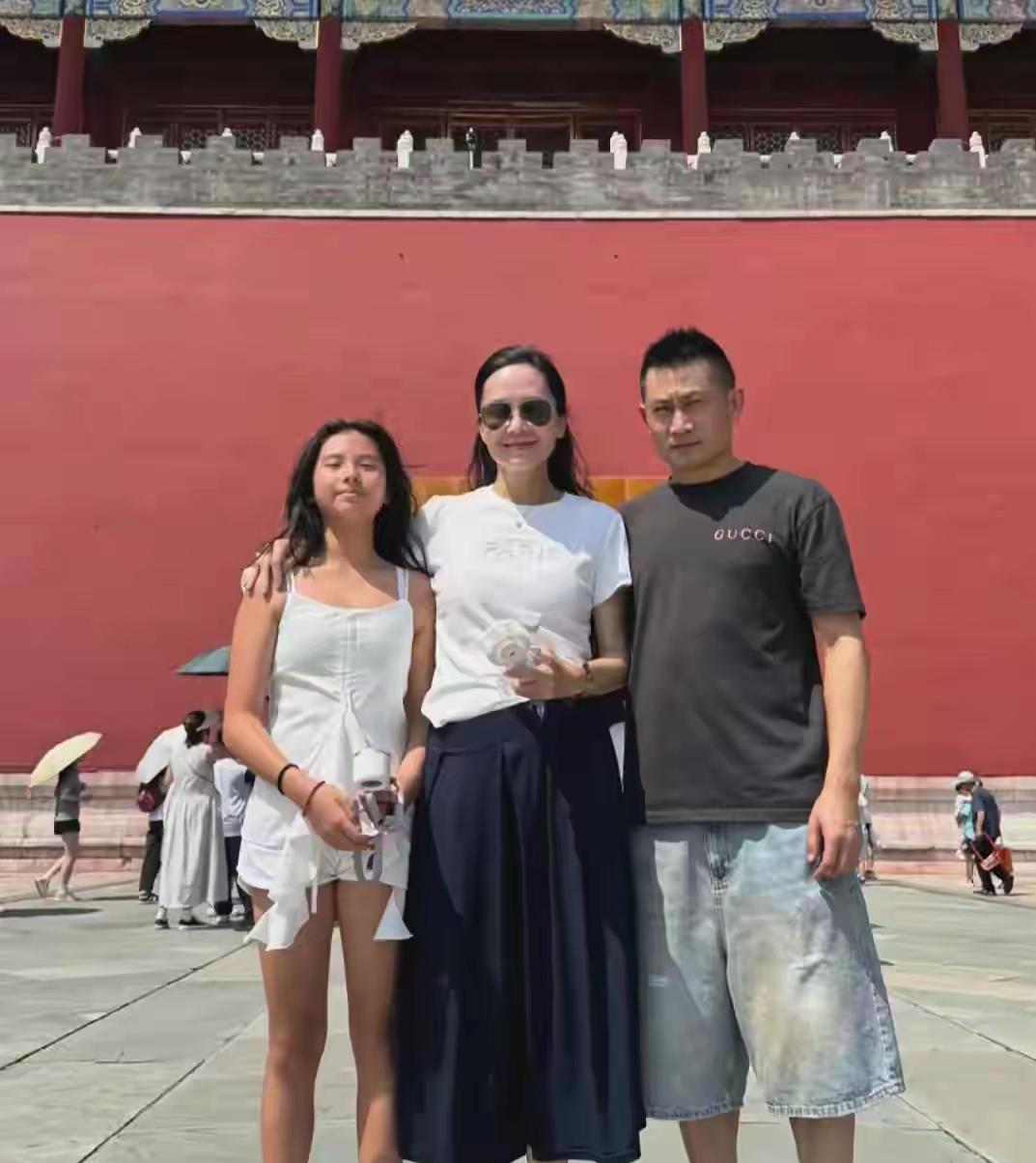刷到在故宫旅游的郭羡妮一家，51岁的她穿着白T恤配藏蓝长裙，手持小风扇，完全看不