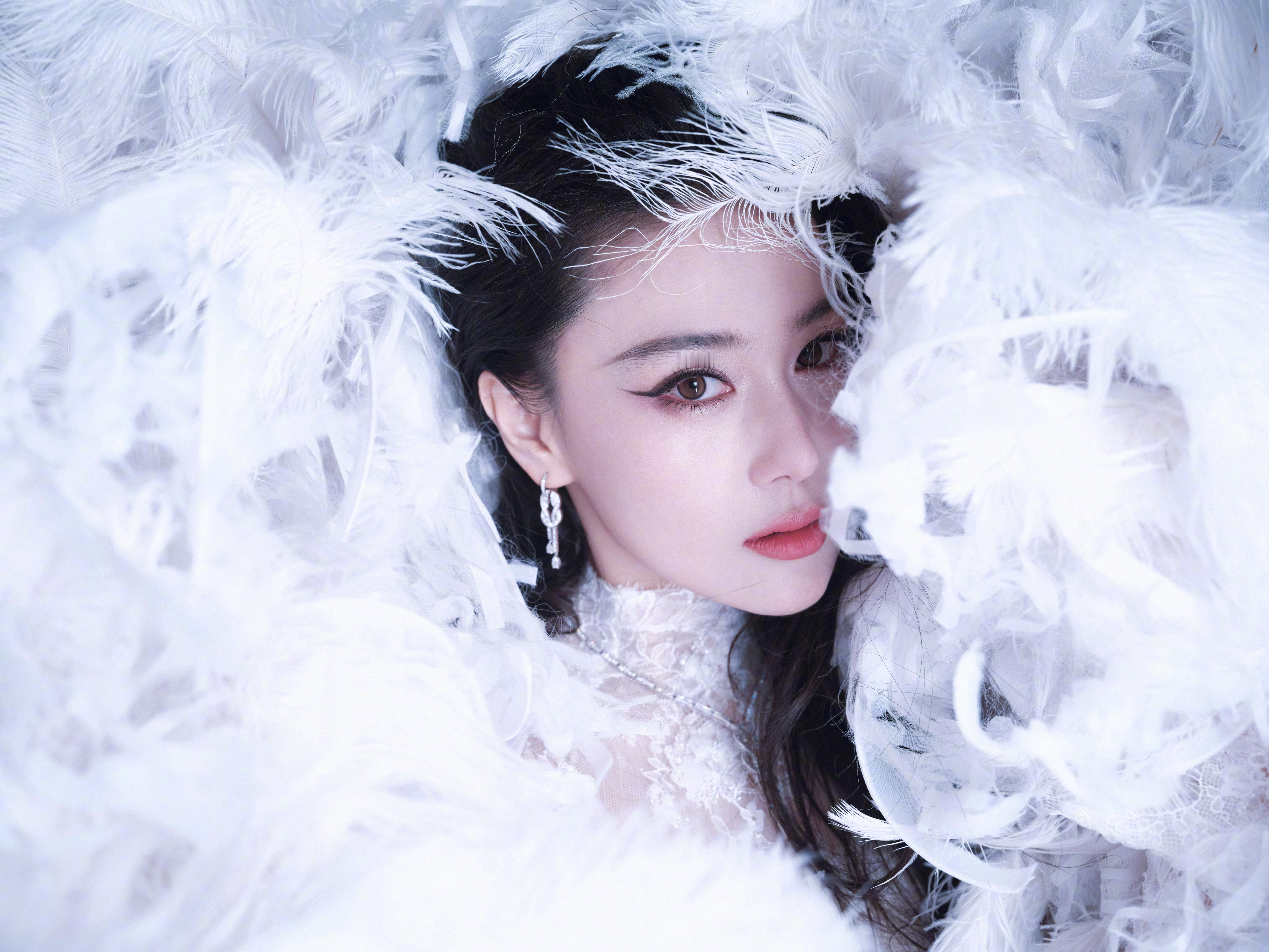 张馨予于纯白羽浪中翩然伫立,蕾丝曳地如月光织就的梦。张馨予化妆师火了