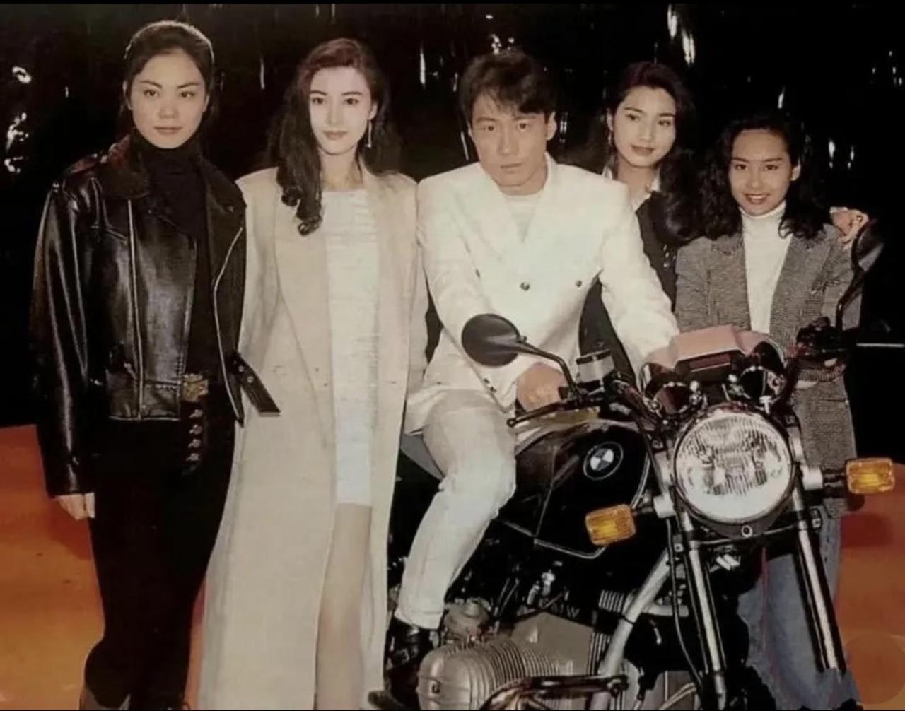 黎明年轻时期的合影照，当时黎明坐在摩托车上与王菲、李嘉欣、洪欣和朱茵合影。黎