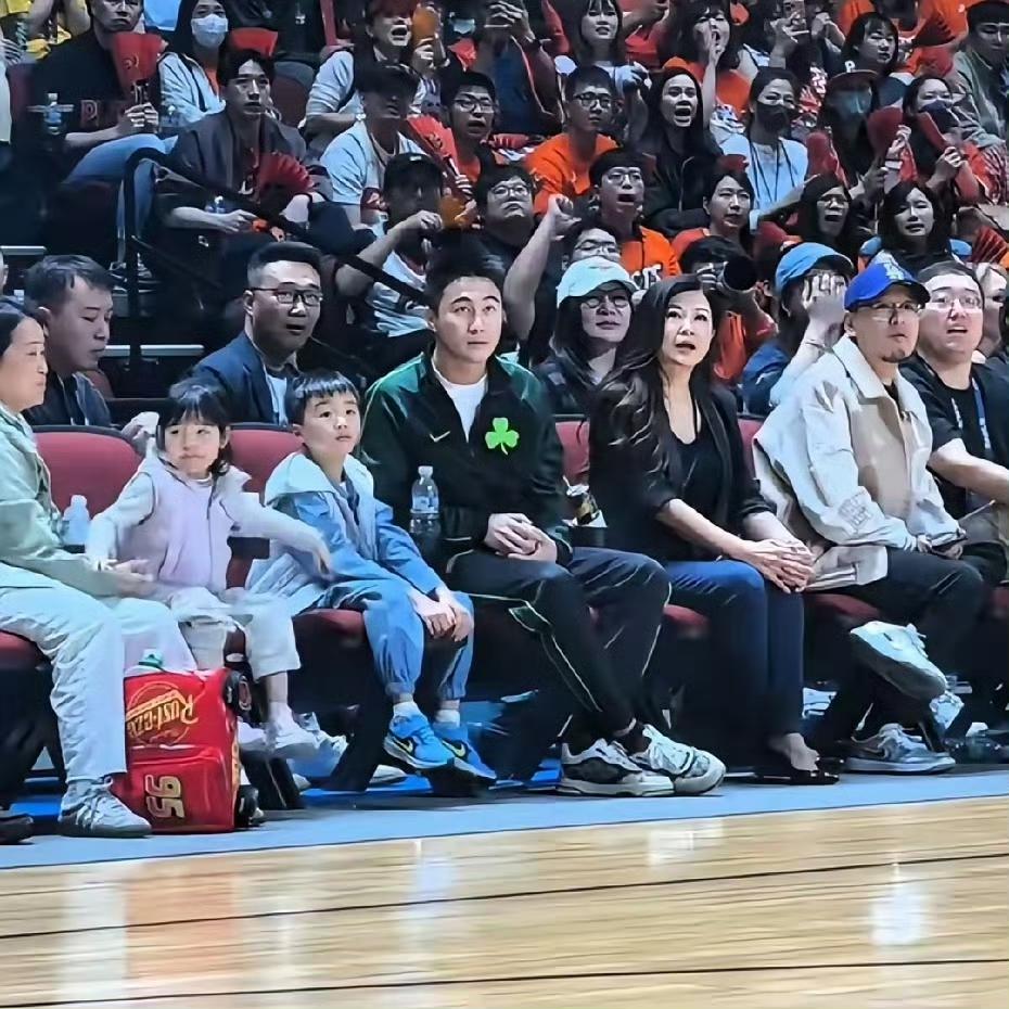 何猷君携一双儿女现身澳门，现场观看东亚超级联赛。两个小家伙看得全神贯注，模样十分