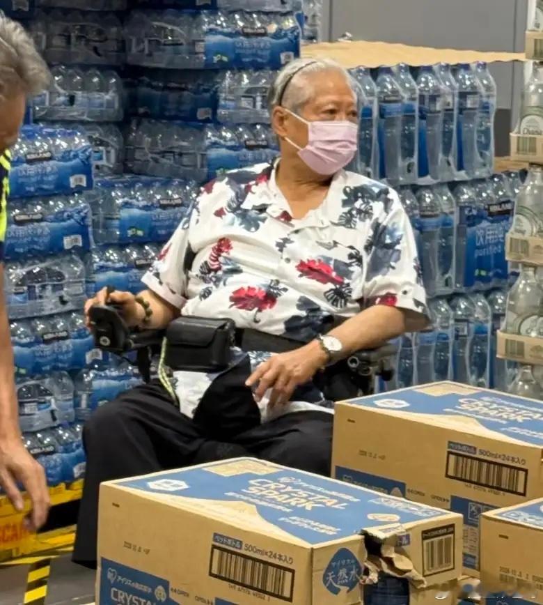 76岁洪金宝在深圳开市客超市购物被偶遇，他坐在轮椅上，身形臃肿，头发苍白，眼神涣