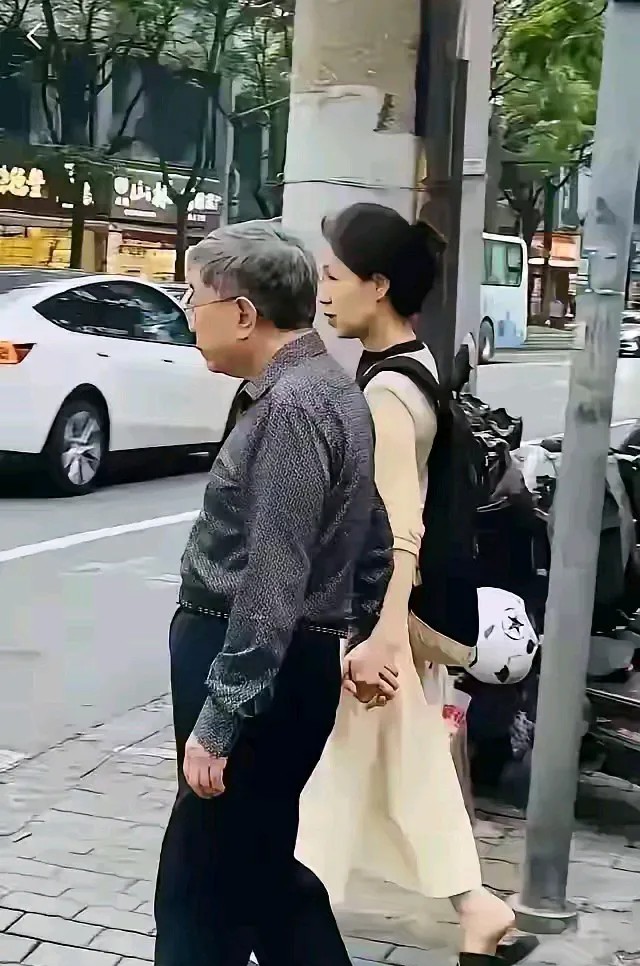 余秋雨和马兰的近照，两个人都不再年轻，牵手在街头散步。余秋雨已经是79岁的老人了