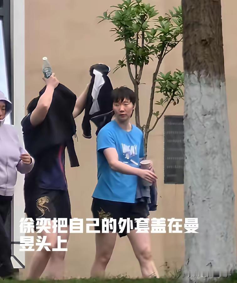 徐奕这个小动作太暖心了！今天成都变天了，下起了小雨。下训的曼昱只穿了短袖运动衫