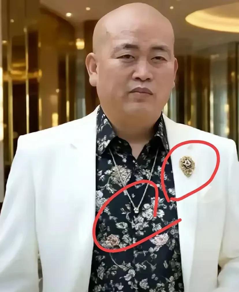 花衬衣，白西服，戴着项链，别着胸针。锃亮的光头，满脸横肉，蔑视一切的眼神。站在金