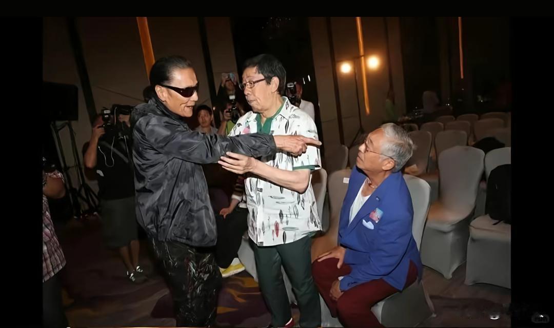 谢贤伸手指向曾江，是老友间开玩笑调侃。胡枫在中间伸手劝解、打圆场，三人是同一时代