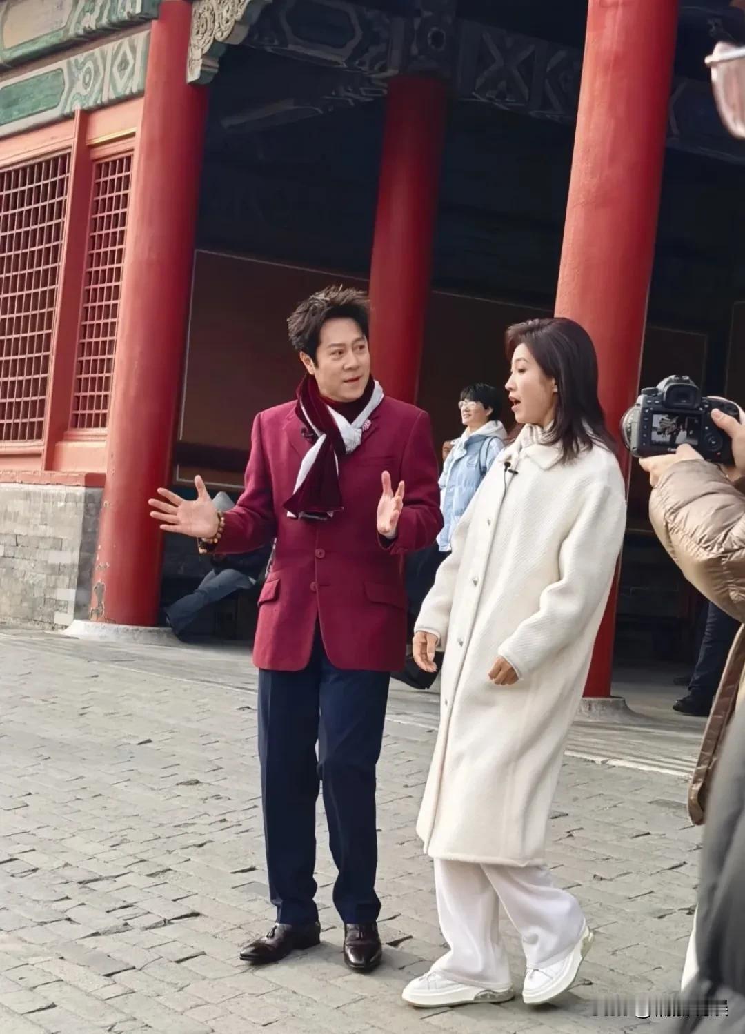 蔡国庆现身北京录节目，穿着一件酒红色西装，戴着花色围巾，脚上穿了一双尖头皮鞋，他