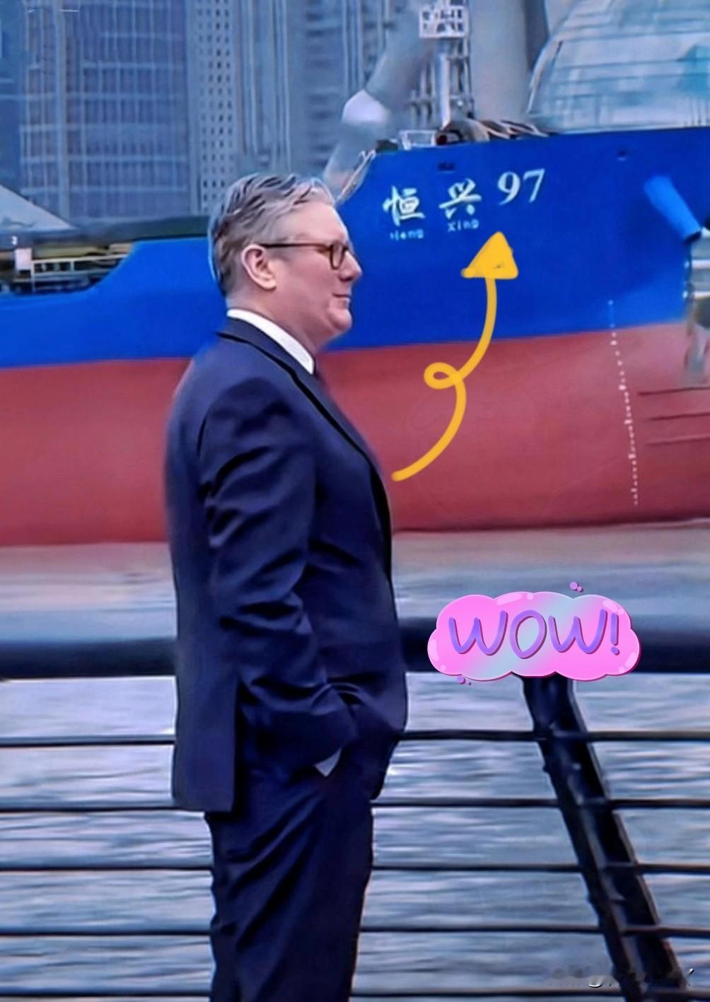 英国首相在上海黄浦江边驻足时，画面背景中缓缓驶过一艘名为“恒兴97”的货轮。