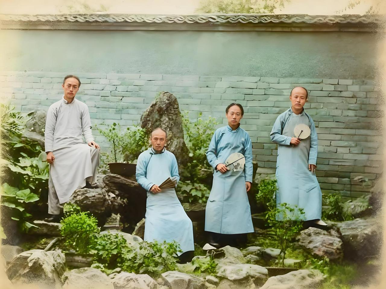 照片里是清末的四位男子，他们身处一处雅致的庭院，周围有山石、绿植点缀，透着大户人