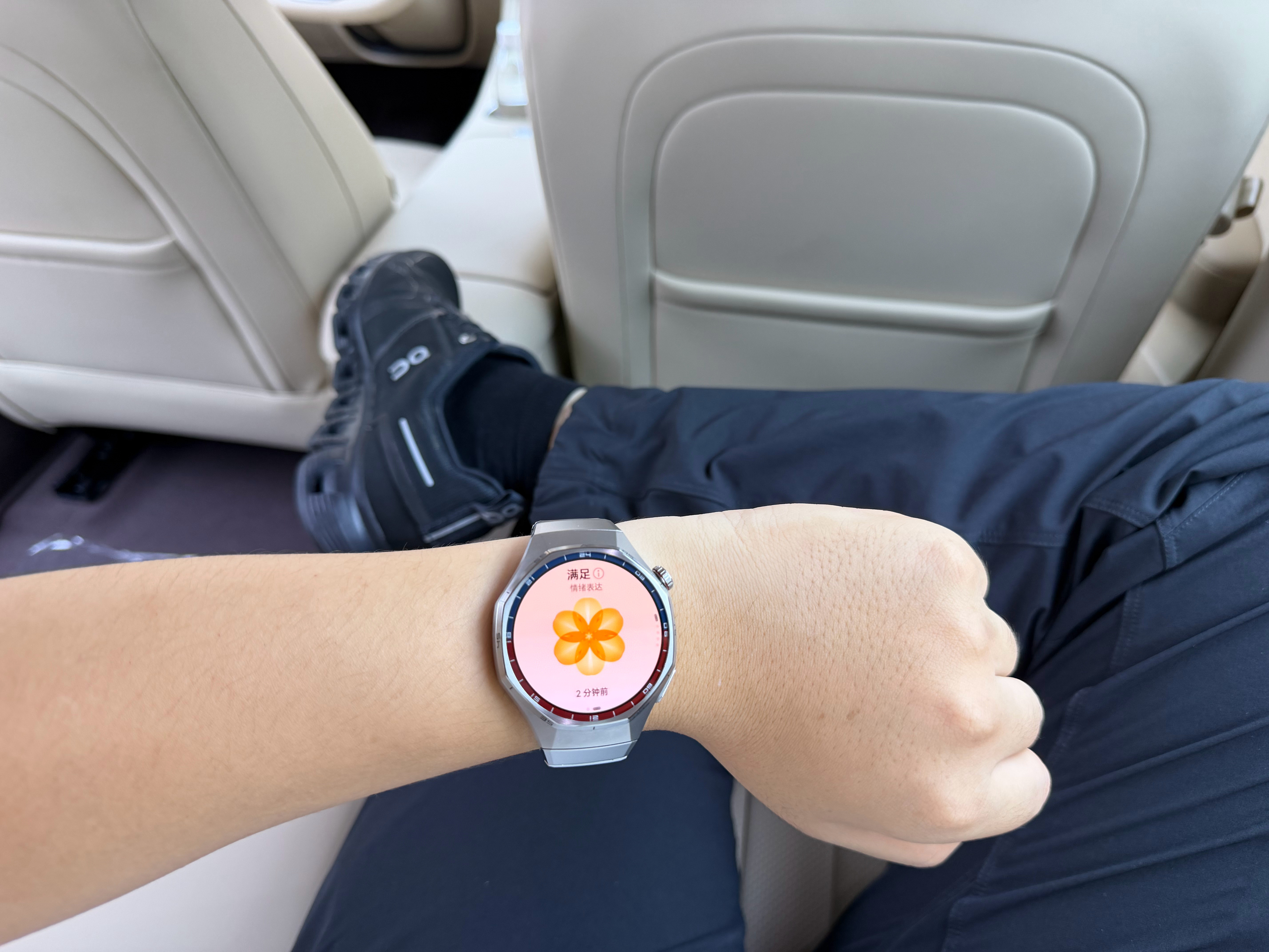 坐在尚界H5的后排，翘起二郎腿，抬起手腕看一眼华为WATCH6Pro的情绪健