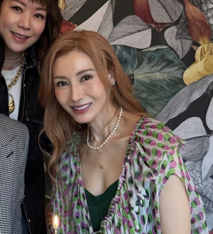 56岁李嘉欣和朋友提前庆祝生日，她穿着一件低胸裙子，留着一头黄毛，脖子上戴着一串