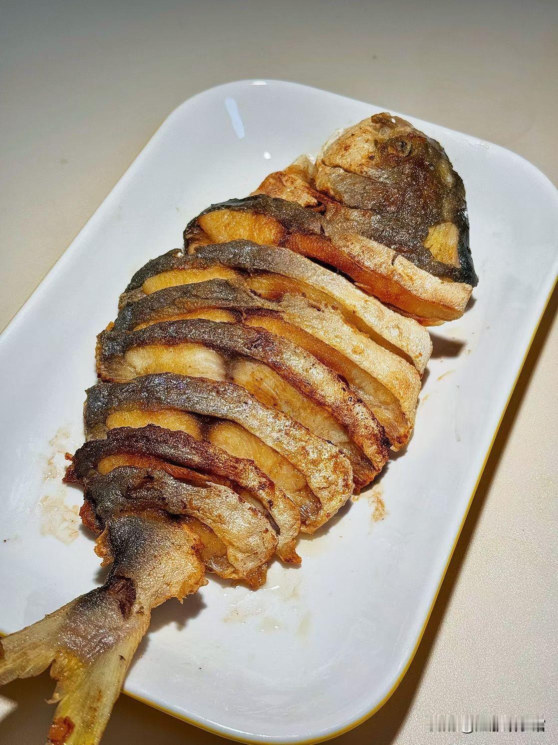 今早突发奇想，把冰箱里冻了半周的金鲳鱼拎出来，改刀成“风琴状”下锅煎。热油