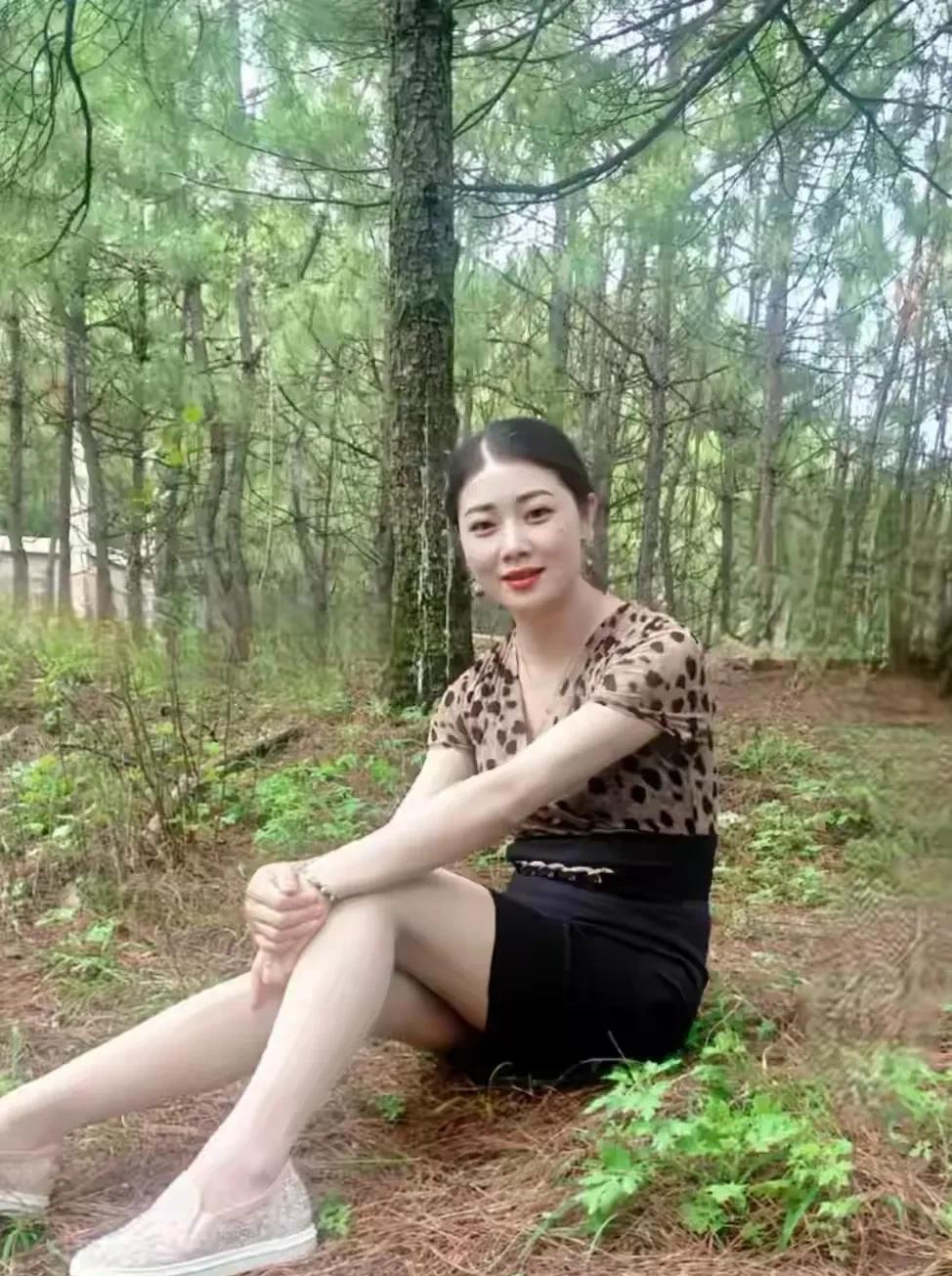 静谧的森林里，一位年轻漂亮的女士坐在溪边的露营椅上。她身着民间服饰，就像从古老故