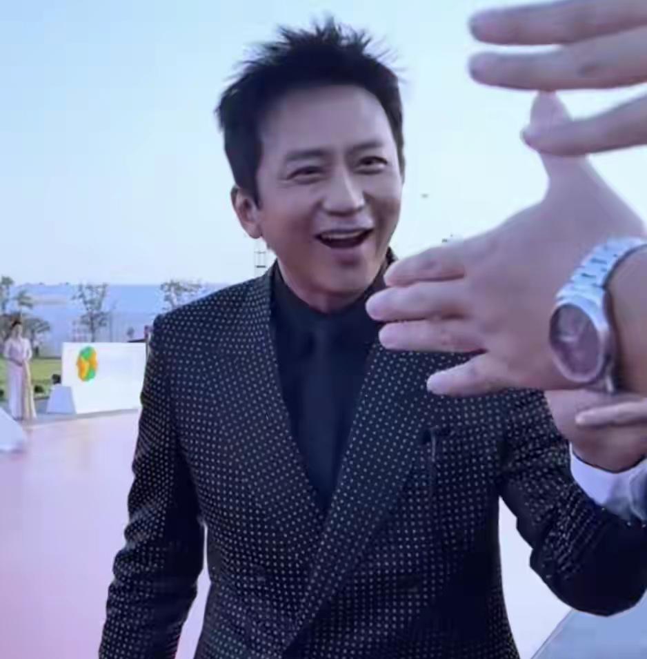 金鸡奖红毯上，46岁的邓超素颜亮相，满脸褶子却难掩真实魅力。他弯腰帮观众捡水、击