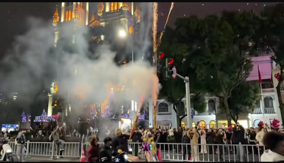 12月31日跨年夜，宁波天一广场，两年轻小伙在放飞气球的人群中，手持“加特林”烟