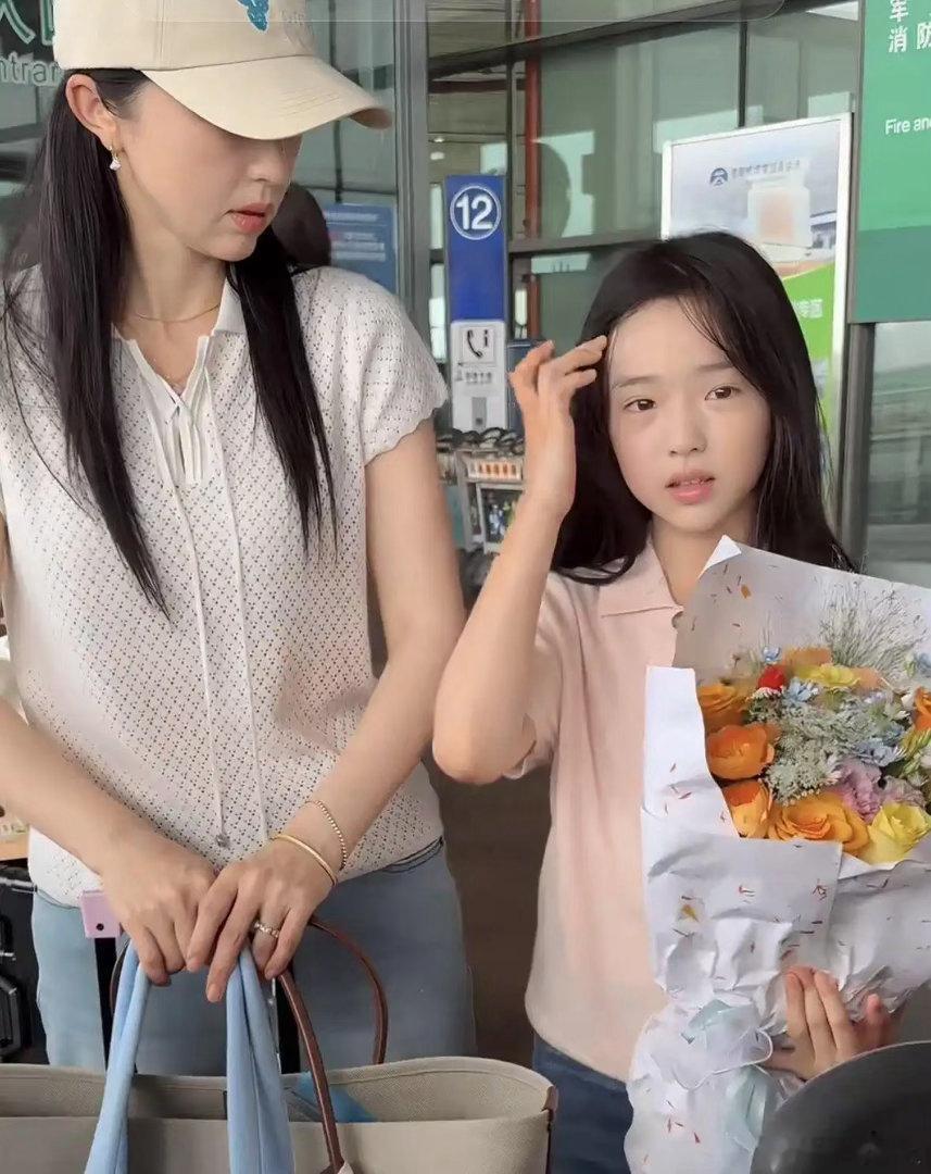 董璇带女儿小酒窝走机场，娃面对镜头大方老练，网友犯嘀咕：小小年纪这么会营业，童真去哪儿了​