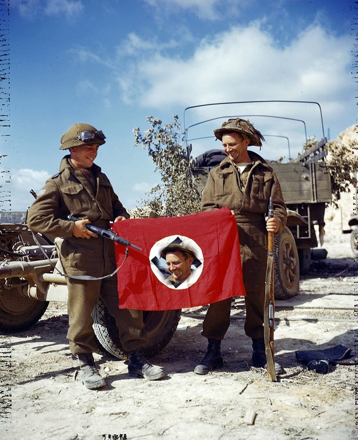 1944年8月10日法国，缴获了德军旗帜的加拿大士兵。