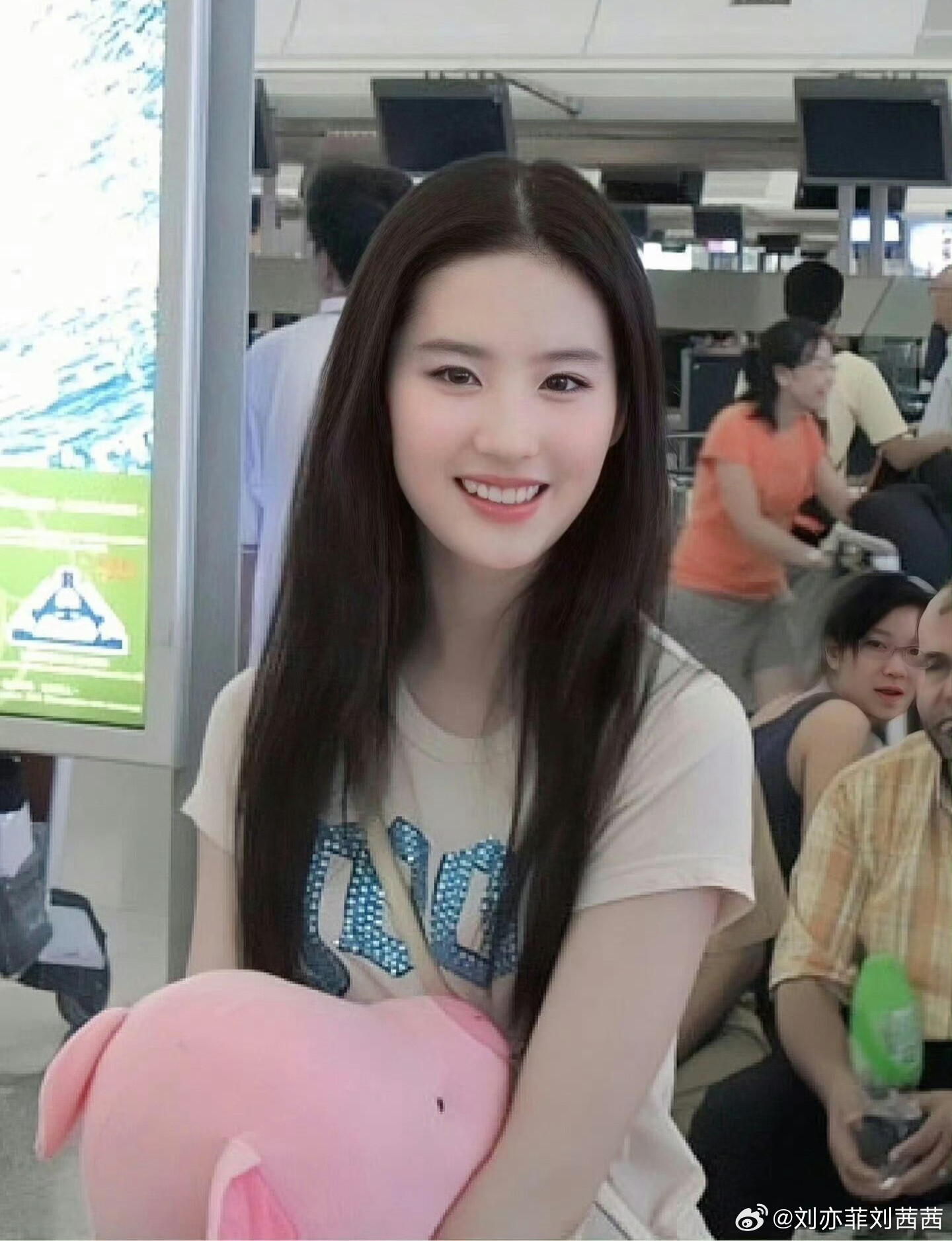 刘亦菲身着的这件浅米色宽松印花短袖，版型简约大方，却又不失细节亮点。亮片字母的设