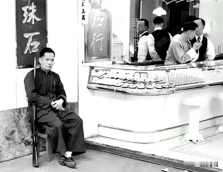 上世纪50年代,香港珠宝玉器行的持枪保安,他虽然坐着,但是枪管却紧紧夹在手臂中,
