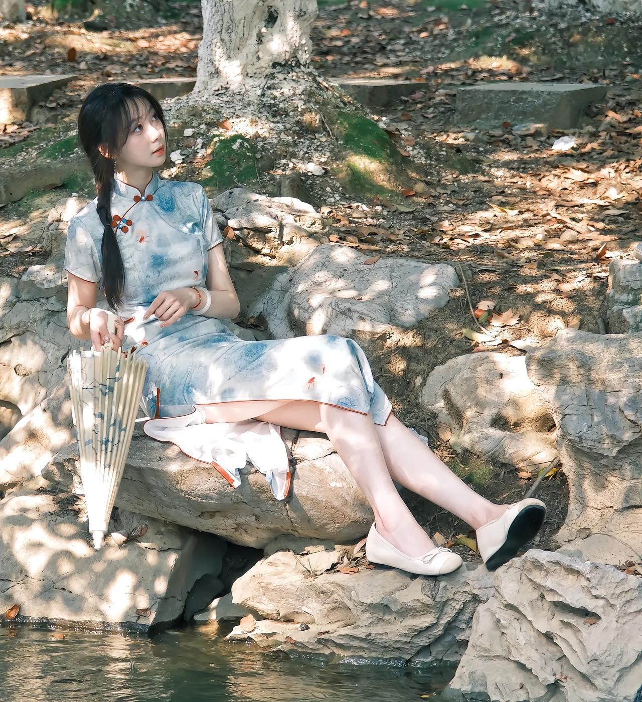 古风少女在树荫下静坐，手持团扇，悠然自得。