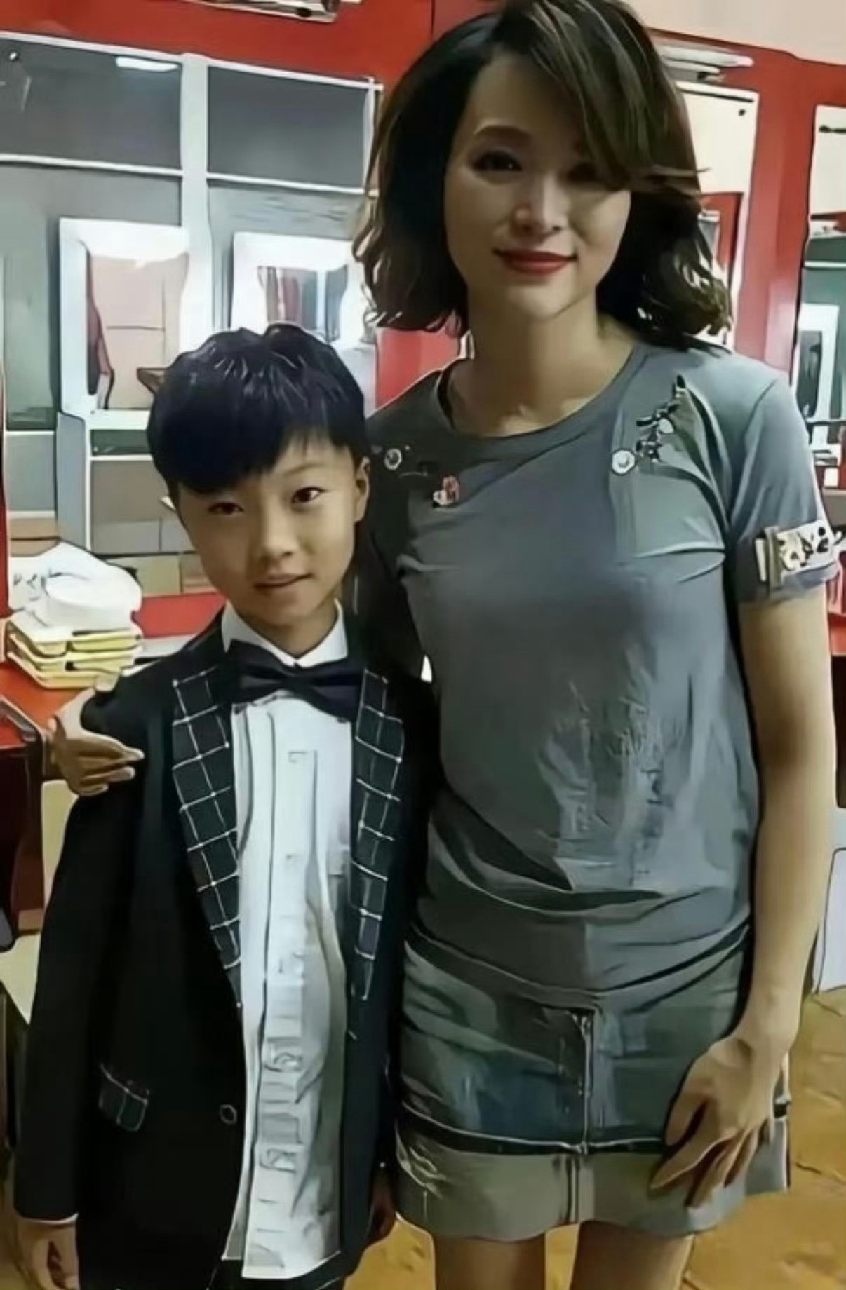 当日她素面短发，穿搭简约素雅，全程安静坐在观众席后排，专心举手机记录孩子上台领奖