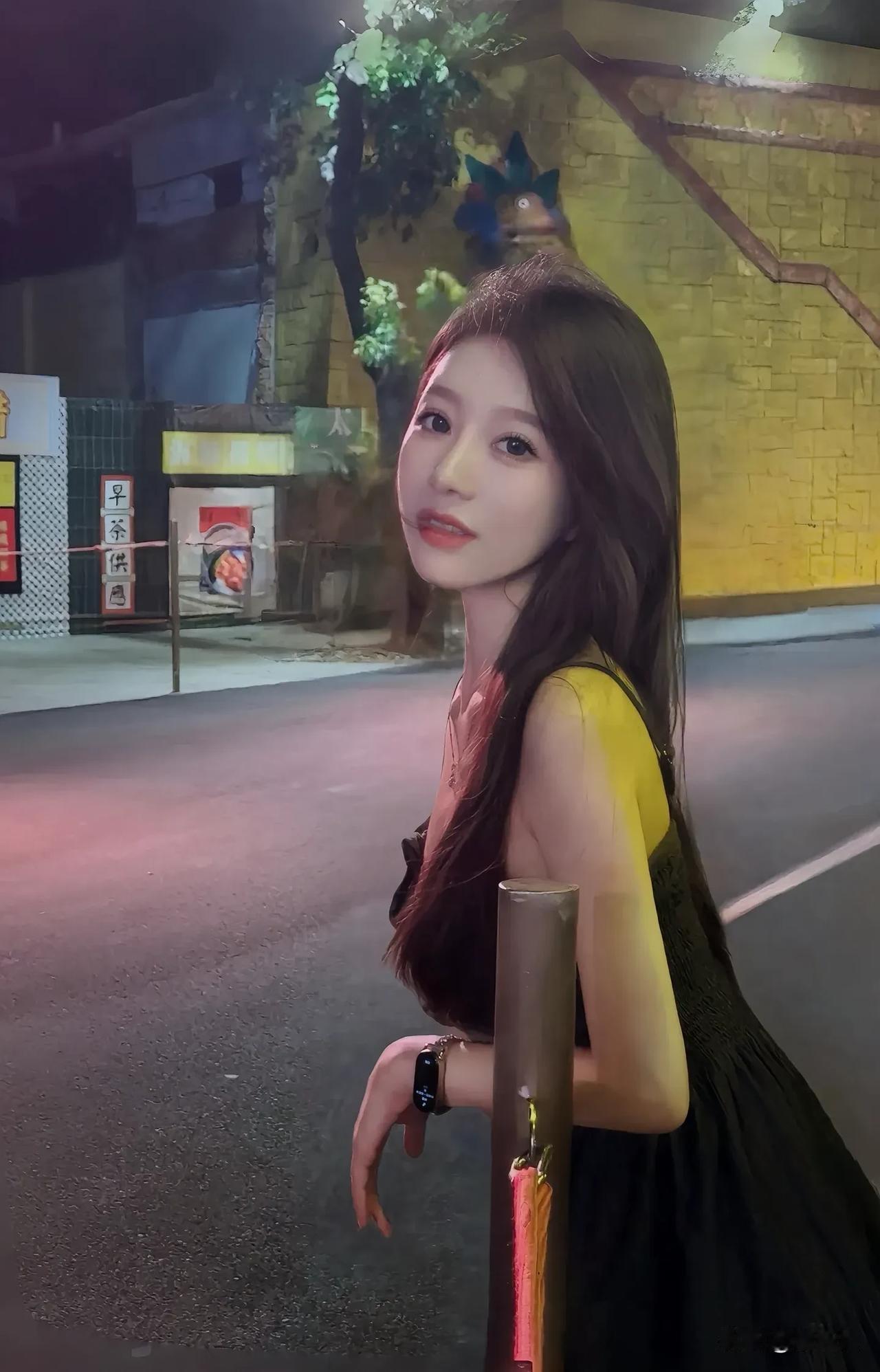 夜晚的街头，少女倚栏而立，灯光下的迷人侧颜