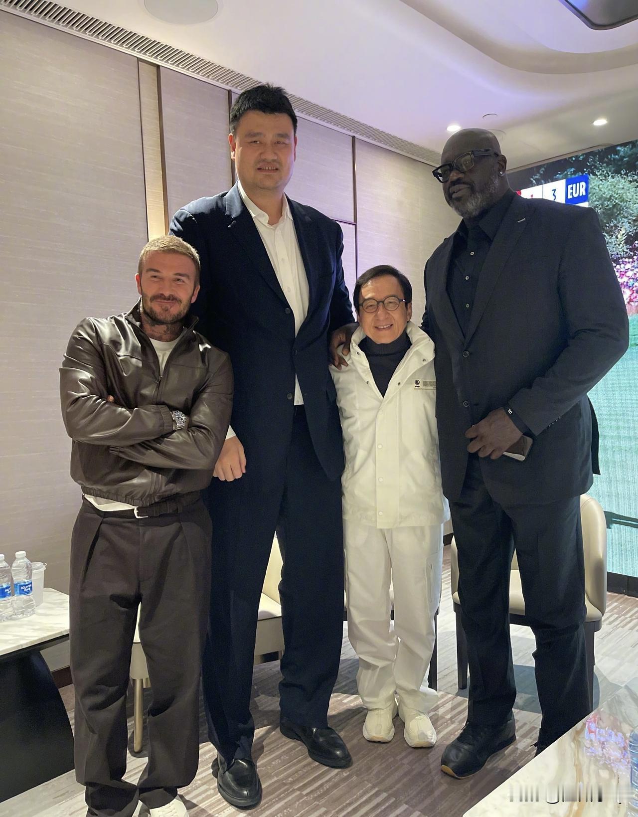 其实成龙大哥不用勉强的，背后就有凳子，站在凳子上拍就可以与姚明奥尼尔持平了。